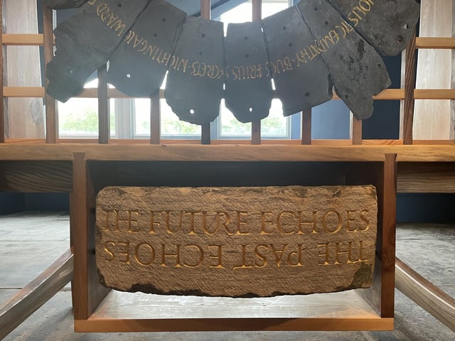 One of the reclaimed stones featured in the Spirit Cabinet artwork carries a circular inscription