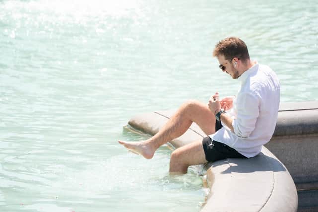 A man paddles in the fountain in Trafalgar Square, central London, as Britons are set to experience the hottest UK day on record as temperatures are predicted to hit 40C. Picture date: Tuesday July 19, 2022.