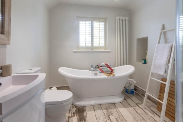A beautifully appointed bathroom, including slipper style double end bath, wall mount wash basin in vanity unit, and separate shower.