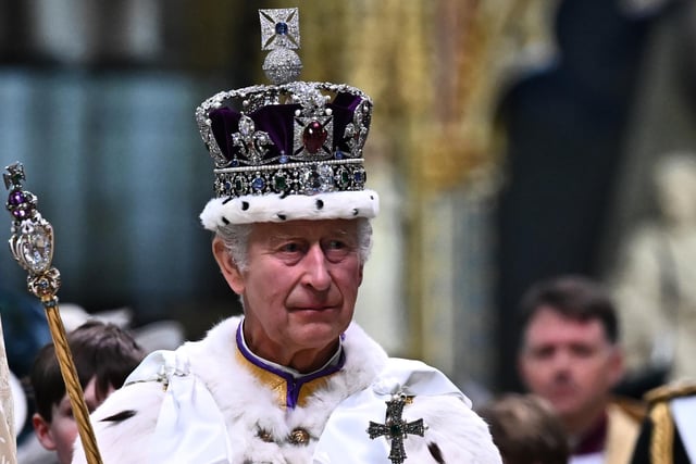 King Charles III wearing the Imperial state Crown carrying the Sovereign's Orb and Sceptre leaves Westminster Abbey after the Coronation Ceremonies. P