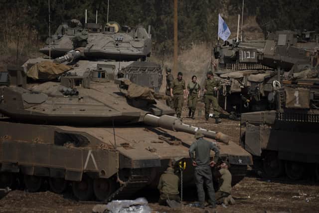 Israeli soldiers work on tanks and armoured personnel carriers in Israel on Monday 30 September, 2024. (AP Photo/Leo Correa)