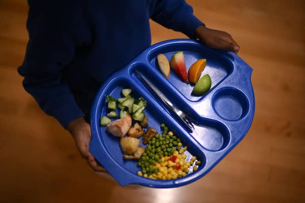 A child carries a tray with food. Free school meals are being extended to P6 and P7 pupils. Picture: Getty Images