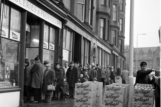 Customers queue outside Mr Munro's shop at Brandon Terrace, in Edinburgh, to stock up for Hogmanay