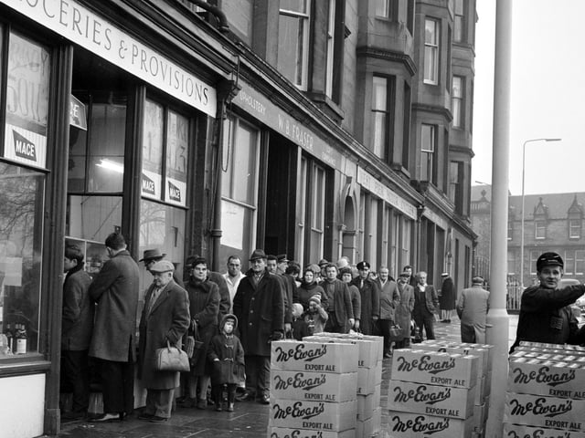Customers queue outside Mr Munro's shop at Brandon Terrace, in Edinburgh, to stock up for Hogmanay
