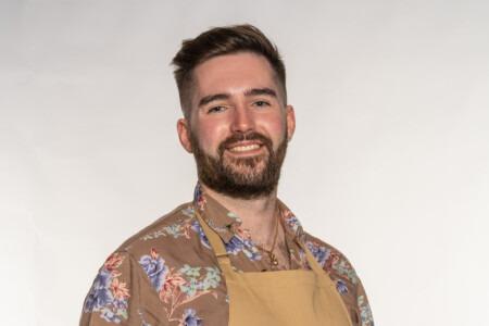 Proud kilt-wearer James grew up in the east-end of Glasgow and moved to England after university. He is a self-proclaimed board game geek and loves horror films from the 70s and 80s. An avid music fan, reflect in his baking style; which is now significantly better than it was during his childhood when he was burning pancakes in his mother’s kitchen! He enjoys the technical side of baking, but is in his element when he makes his bakes his own, with his signature ‘child-friendly horror’ style and adorable decoration. His favourite flavours are anything autumnal, such as mixed spice, apples and caramel.