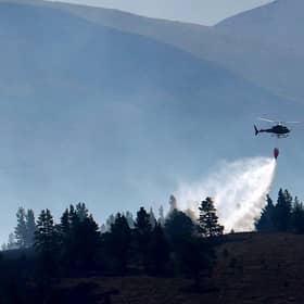 A helicopter water bombs the Cairngorm wildfire that has burned for weeks after breaking out last month (Picture: Jeff J Mitchell/Getty Images)
