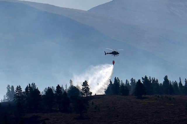 A helicopter water bombs the Cairngorm wildfire that has burned for weeks after breaking out last month (Picture: Jeff J Mitchell/Getty Images)