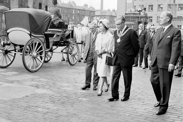 A view of Queen Elizabeth II admiring one of the coaches during a visit to St Cuthberts Transport Department, in Edinburgh, in June 1966.