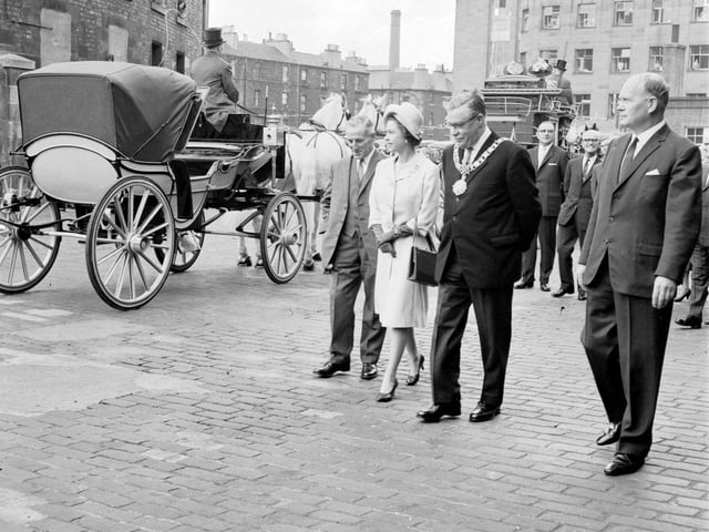 A view of Queen Elizabeth II admiring one of the coaches during a visit to St Cuthberts Transport Department, in Edinburgh, in June 1966.