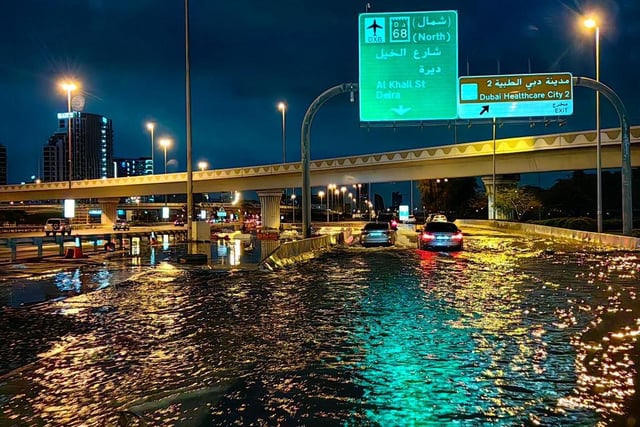 Motorists drive along a flooded street following heavy rains in Dubai early this morning.