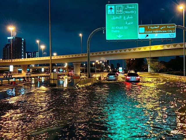 Motorists drive along a flooded street following heavy rains in Dubai early this morning.