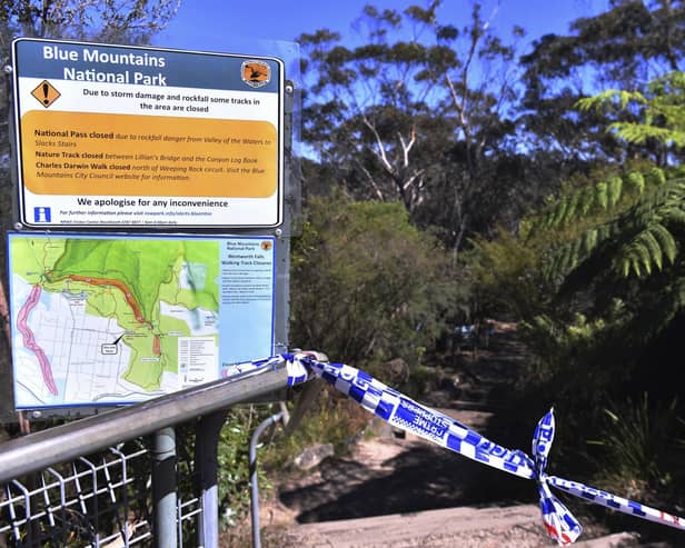The entrance to the walking track where a landslide killed 2 and injured two others is tapped off at Wentworth Falls in the Blue Mountains, west of Sydney, Tuesday, April 5, 2022. A British family of five was caught in a landslide while walking in Australia's Blue Mountains, and the father and 9-year-old son died. (Dean Lewins/AAP Image via AP)