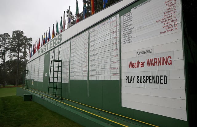 The scoreboard is updated with a "weather warning" and "play suspended" sign during the first round of the Masters at Augusta National Golf Club. Picture: Rob Carr/Getty Images