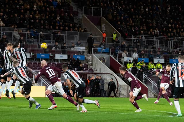 Stephen Kingsley curls home Hearts' second goal.