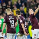 Hearts' Lawrence Shankland takes a bite of a pie that was thrown at him during the last Edinburgh derby.