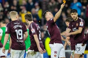 Hearts' Lawrence Shankland takes a bite of a pie that was thrown at him during the last Edinburgh derby.