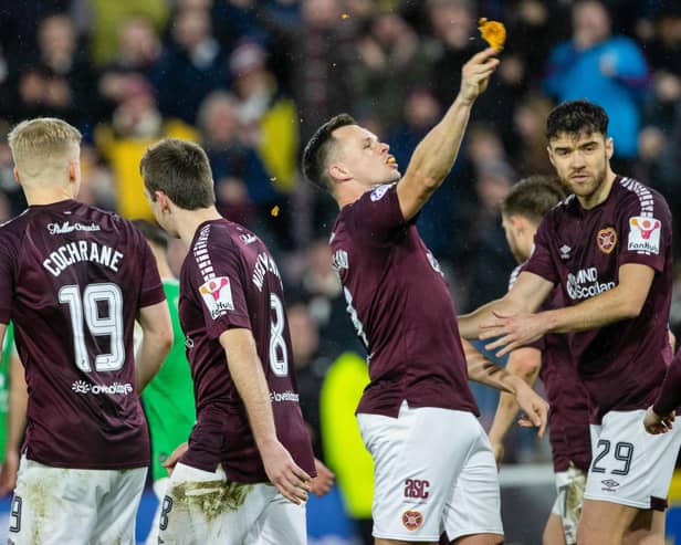 Hearts' Lawrence Shankland takes a bite of a pie that was thrown at him during the last Edinburgh derby.