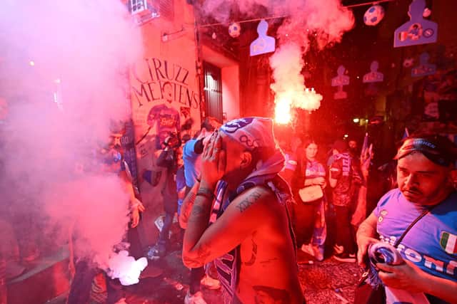A Napoli fan cannot hide his emotion at the Largo Maradona in the Quartieri Spagnoli district of Naples following his team's Scudetto triumph.