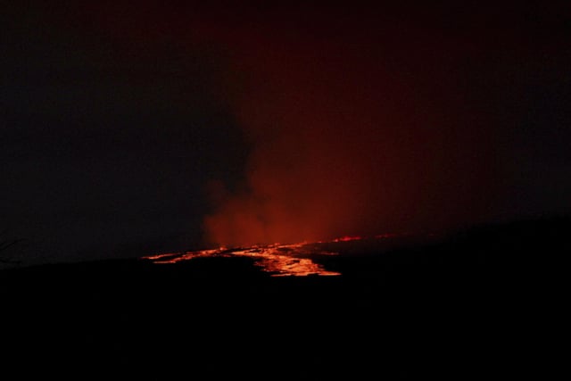 Lava pours out of the summit crater of Mauna Loa about 6:35 a.m. Monday, Nov. 28, 2022, as seen from Gilbert Kahele Recreation Area on Maunakea, Hawaii. Mauna Loa, the worldâ€™s largest active volcano, began spewing ash and debris from its summit, prompting civil defense officials to warn residents on Monday to prepare in case the eruption causes lava to flow toward communities. (Chelsea Jensen/West Hawaii Today via AP)