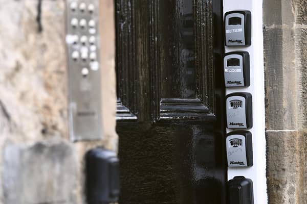 Key safes at the door of a block of flats in Edinburgh point to Airbnb-style holiday flats inside (Picture: Lisa Ferguson)