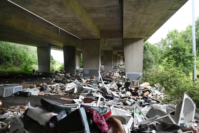 Baths, asbestos, washing machines and bin bags piled up under the M8 motorway earlier this year. Picture: John Devlin
