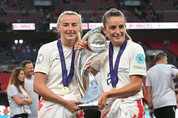 Goalscorers England's striker Chloe Kelly (L) and England's midfielder Ella Toone (R) pose with the trophy as England's players celebrate their Euro 2022 win. (Photo by JUSTIN TALLIS/AFP via Getty Images)