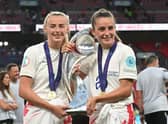 Goalscorers England's striker Chloe Kelly (L) and England's midfielder Ella Toone (R) pose with the trophy as England's players celebrate their Euro 2022 win. (Photo by JUSTIN TALLIS/AFP via Getty Images)
