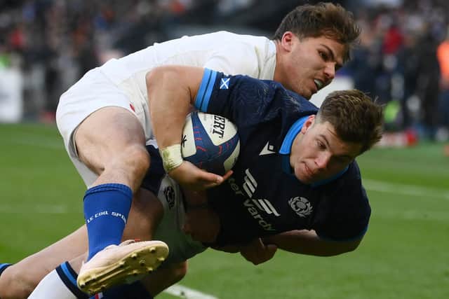 Scotland's centre Huw Jones scores a try as France's scrum-half Antoine Dupont attempts to tackle during the Six Nations match in Paris. (Photo by FRANCK FIFE/AFP via Getty Images)