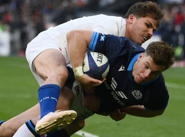 Scotland's centre Huw Jones scores a try as France's scrum-half Antoine Dupont attempts to tackle during the Six Nations match in Paris. (Photo by FRANCK FIFE/AFP via Getty Images)