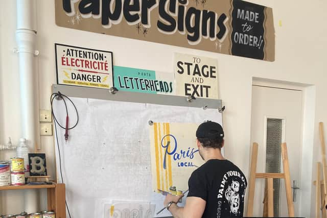 Vincent Audoin, a Parisian artisan, painting a sign in his studio. Pic: Sophie Goodall/PA Wire