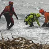 Rescuers recover a body after a migrant boat broke apart in rough seas, at a beach near Cutro in southern Ital. Picture: AP Photo/Giuseppe Pipita