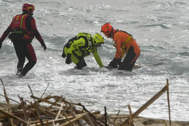 Rescuers recover a body after a migrant boat broke apart in rough seas, at a beach near Cutro in southern Ital. Picture: AP Photo/Giuseppe Pipita