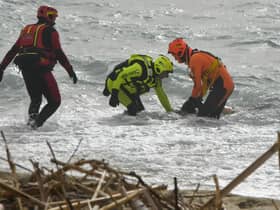 Rescuers recover a body after a migrant boat broke apart in rough seas, at a beach near Cutro in southern Ital. Picture: AP Photo/Giuseppe Pipita