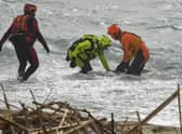 Rescuers recover a body after a migrant boat broke apart in rough seas, at a beach near Cutro in southern Ital. Picture: AP Photo/Giuseppe Pipita