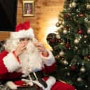 Santa Claus puts on his glasses before taking part in a video call with a family (Picture: Niklas Halle'n/AFP via Getty Images)