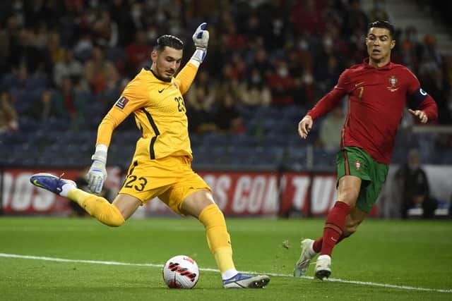 Turkey goalkeeper Ugurcan Cakir clears the ball past Portugal's Cristiano Ronaldo during a World Cup 2022 play-off semi-final in 2022. (Photo by MIGUEL RIOPA/AFP via Getty Images)