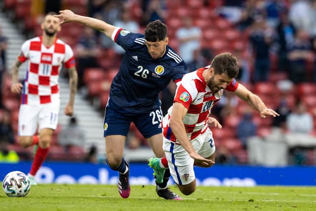 Scotland's Scott McKenna picks up a yellow card for a foul on Bruno Petkovic.