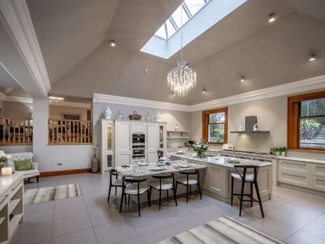 The generous kitchen is fitted with a vast and comprehensive range of Charles York cabinets, complemented by granite bevelled worksurfaces and a centre island.