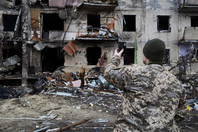 A Ukrainian soldier surveys the damage to a residential building in Kyiv after it was hit by a missile (Picture: Pierre Crom/Getty Images)