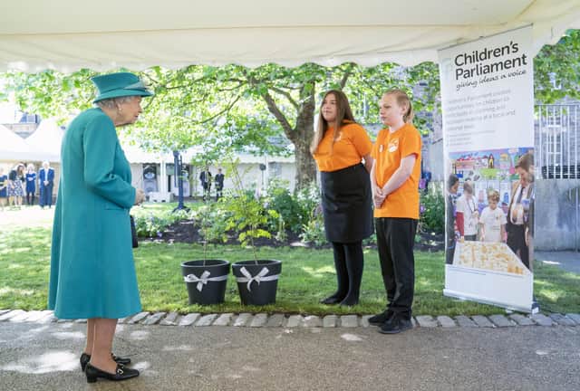 Queen Elizabeth is presented with trees by members of the Children's Parliament during a visit to the Edinburgh Climate Change Institute, as part of her traditional trip to Scotland for Holyrood Week on July 1, 2021 in Edinburgh, Scotland. (Photo by Jane Barlow - WPA Pool/Getty Images)