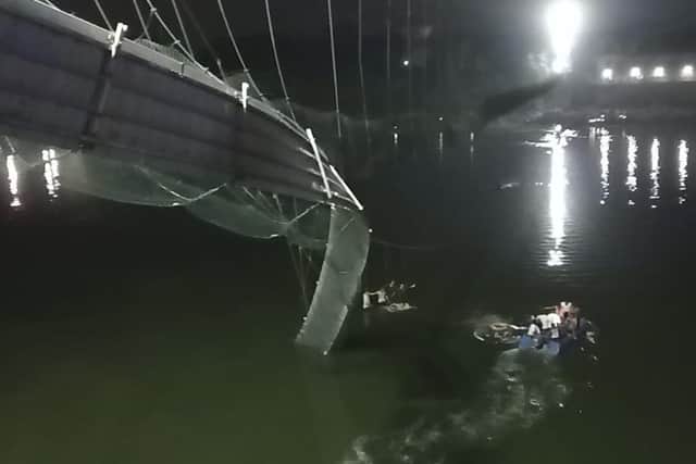 Rescuers on boats search in the Machchu river next to a cable bridge that collapsed in Morbi district, western Gujarat state, India.