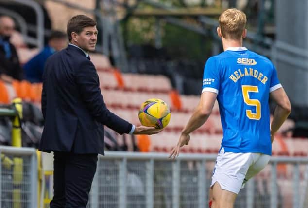 Rangers manager Steven Gerrard hands the ball to defender Filip Helander during his team's Premiership match against Dundee United at Tannadice on Saturday. (Photo by Craig Williamson / SNS Group)
