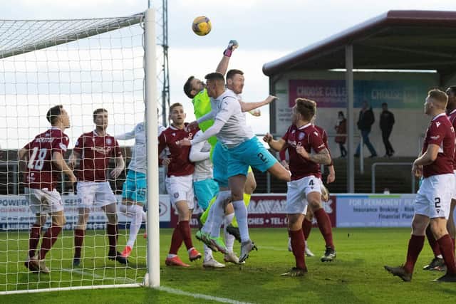Arbroath's Derek Gaston attempts to punch clear under pressure from Inverness' Shane Sutherland.