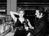Spanish fashion designer Paco Rabanne tries a creation with cutleries on French actress Corinne Marchand during the Home economics (or domestic science) exhibition at the shopping mall of Saint-Laurent-du-Var.