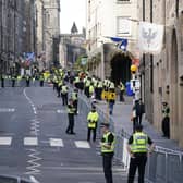 Police officers on the Royal Mile in Edinburgh. Queen Elizabeth II's coffin will be transported on a six-hour journey from Balmoral to the Palace of Holyroodhouse in Edinburgh, where it will lie at rest. Picture date: Sunday September 11, 2022.