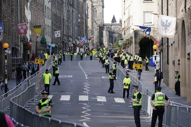 Police officers on the Royal Mile in Edinburgh. Queen Elizabeth II's coffin will be transported on a six-hour journey from Balmoral to the Palace of Holyroodhouse in Edinburgh, where it will lie at rest. Picture date: Sunday September 11, 2022.