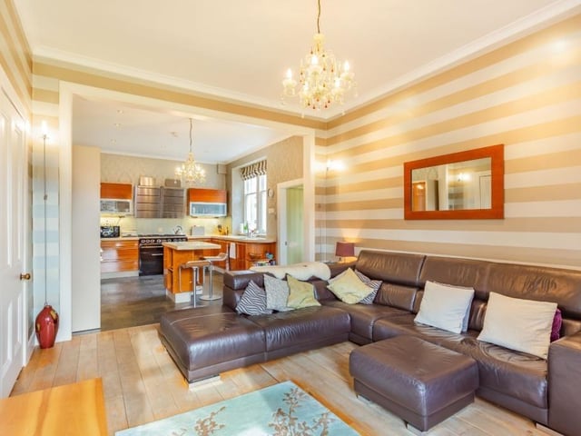 The sitting area has exposed wooden flooring and feature open fireplace.