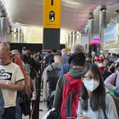 Travellers queue at security at Heathrow Airport in London