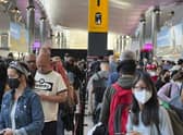 Travellers queue at security at Heathrow Airport in London
