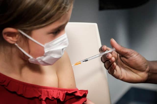 (FILES) This file photo taken on December 17, 2021 shows a child receiving a dose of the Pfizer/BioNTech vaccine against Covid-19, in Paris. - The vaccination of children aged 5 to 11 is officially open, French Health Minister Olivier Veran announced on December 22, 2021, although he said the booster dose had not been extended to teenagers "for the moment". (Photo by GEOFFROY VAN DER HASSELT / AFP) (Photo by GEOFFROY VAN DER HASSELT/AFP via Getty Images)